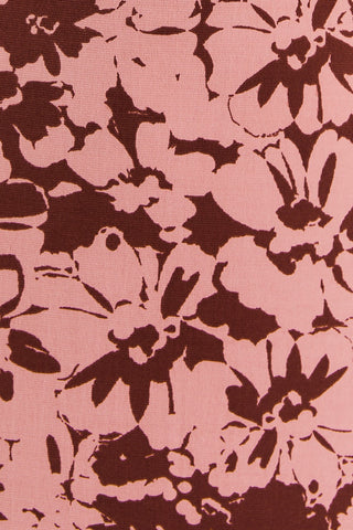 Close-up of the FUAX WRAP MIDI DRESS by Shop-Peppermint shows sleeveless floral fabric in dark brown and pink, with abstract flowers and overlapping petals.
