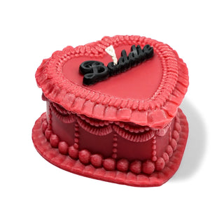 Red heart-shaped cake with 'Baddie' on top against a white background