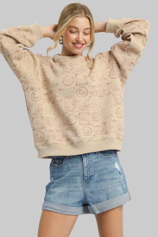 Woman wearing a beige textured sweatshirt and denim shorts on a white background