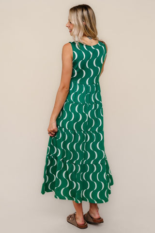 Woman wearing a green dress with white wave pattern on a beige background