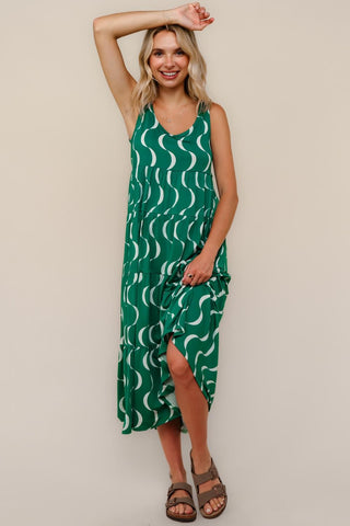 Woman wearing a green patterned dress against a beige background