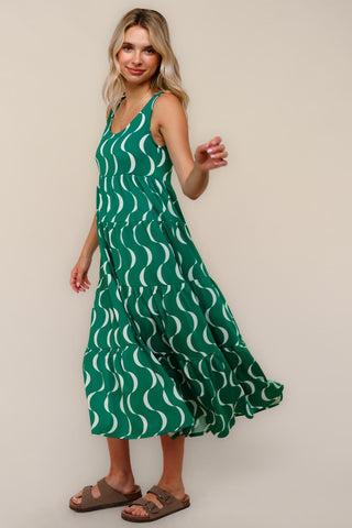 Woman wearing a green dress with white wave pattern on a beige background