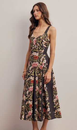 Woman wearing a floral dress against a plain background