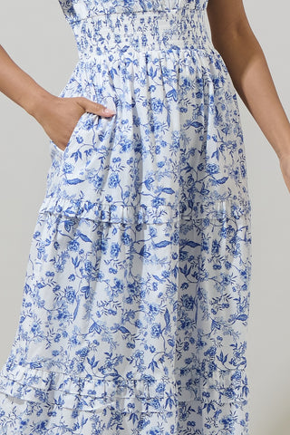 Woman wearing a blue floral dress against a neutral background
