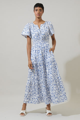 Woman wearing a blue floral dress against a plain background